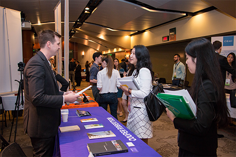 two students speaking to employer at event